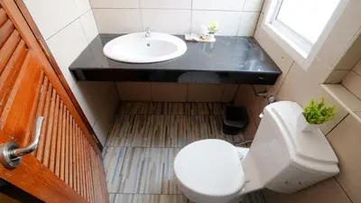 a bathroom with a white toilet and a sink at One Deves in Bangkok