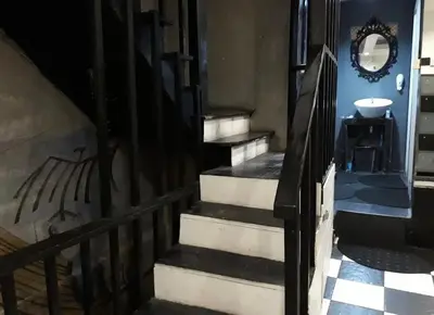 a staircase in a house with a painting on the wall at 24 hr Hostel in khaosan road in Bangkok
