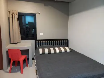 a bedroom with a bed and a red chair at Mimi Cozy Apartment- Old town Siriraj Wanglang Market in Bangkok