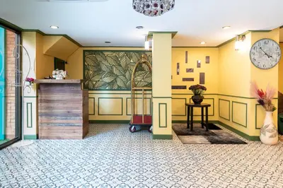 a lobby with yellow walls and a clock at 75 Paradise Lane Managed by Loft Group in Bangkok