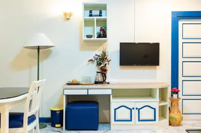 a desk in a room with a tv on a wall at 75 Paradise Lane Managed by Loft Group in Bangkok