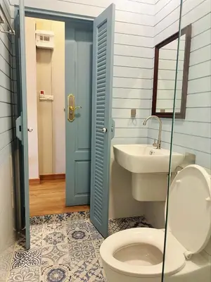 a bathroom with a toilet and a sink at Wiengket Heritage 1964 in Bangkok