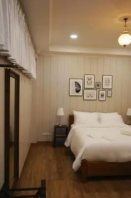 a bedroom with a large white bed and a mirror at Wiengket Heritage 1964 in Bangkok