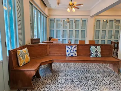 a wooden bench in a room with windows at Wiengket Heritage 1964 in Bangkok