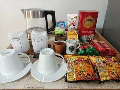 a table with a blender and cups and snacks at Condo I-House Laguna Garden RCA - Behind Sukhumvit Thonglor Asoke Emporium Bangkok Hospital Piyavet Hospital Makkasan Airport Link MRT SKY TRAIN in Bangkok