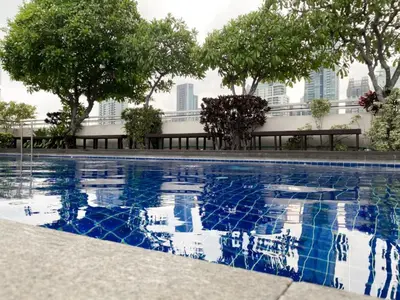 a swimming pool with trees and buildings in the background at Spacious 53 SQM - BTS Thong Lo - Ultra Fast WiFi in Khlong Toei