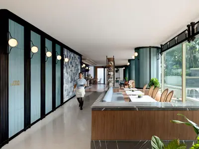 a person walking down a hallway in a building at Dusit Thani Bangkok in Bangkok