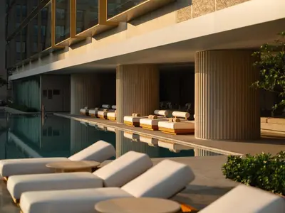 a swimming pool with chaise lounge chairs next to a building at Dusit Thani Bangkok in Bangkok