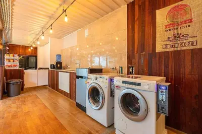 a laundry room with a washer and dryer in it at My Cocoon Hostel แจ้งวัฒนะ in Nonthaburi