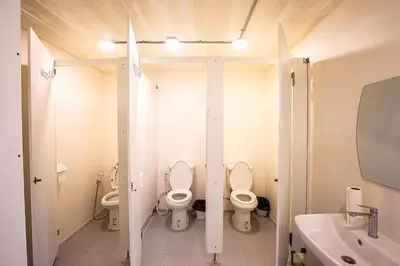 a bathroom with two toilets and a sink at My Cocoon Hostel แจ้งวัฒนะ in Nonthaburi
