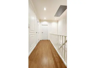 a hallway with white walls and wood floors and a staircase at Cozy House,4 rooms, bts ,Mega Bangna,Suvarnabhumi in Bangkok