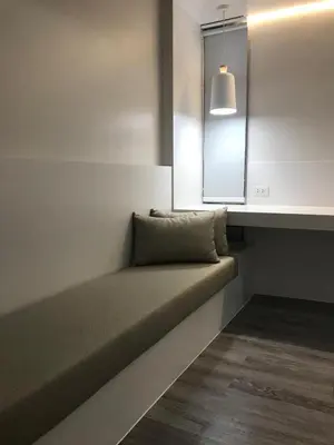 a bed in a room with a window and a light at Urban house in Bangkok
