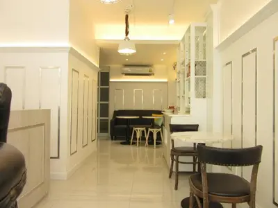 a living room with a table and chairs and a kitchen at Urban house in Bangkok