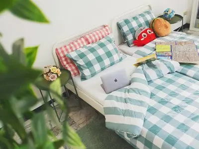 a bed with pillows and a laptop on it at Single Beds, Private Bath & Balcony, Shared Kitchen with Local Family by Pillows & Purrs in Bangkok