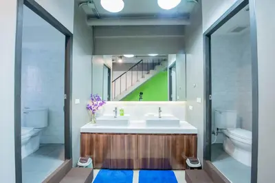 a bathroom with two sinks and a toilet at Mascotte Hostel Silom in Bangkok