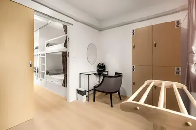 a bedroom with a bed and a desk and a chair at The 63rd Hostel in Bangkok