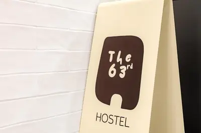 a surfboard with the hostel sign on a wall at The 63rd Hostel in Bangkok