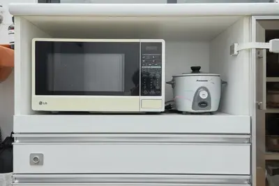 a microwave oven sitting on a shelf with a slow cooker at Spacious Design Loft with Rooftop in Bangkok