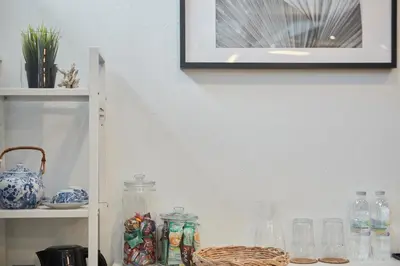 a shelf with glass jars and a picture on the wall at Spacious Design Loft with Rooftop in Bangkok