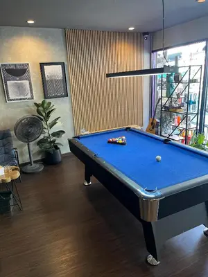 a pool table in a living room with at Bud Brew Beyond Dispensary and Hotel in Bangkok