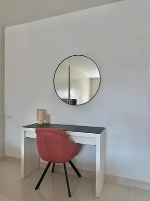 a desk with a red chair and a mirror at Baan Farang in Bangkok