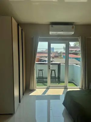 a bedroom with a bed and a view of a balcony at Baan Farang in Bangkok