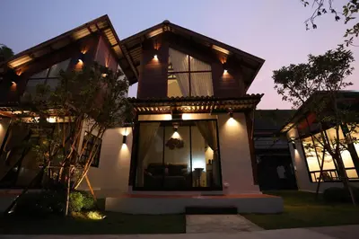 a house with lights on the side of it at Baanrongmai Canal Front Homestay in Bang Chak