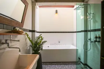 a bathroom with a tub and a sink and a shower at Baanrongmai Canal Front Homestay in Bang Chak