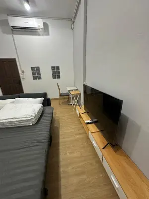 a room with a bed and a flat screen tv at Bee House 172 only 300m to BTS Talat Phlu in Bangkok