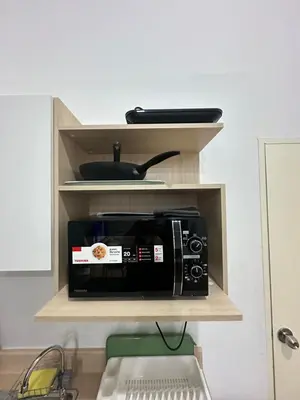 a microwave on a shelf in a kitchen at Bee House 172 only 300m to BTS Talat Phlu in Bangkok