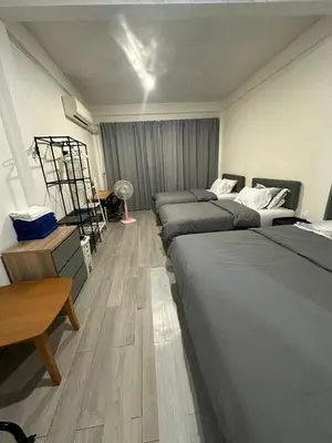 a room with four beds and a table and a desk at Bee House 172 only 300m to BTS Talat Phlu in Bangkok