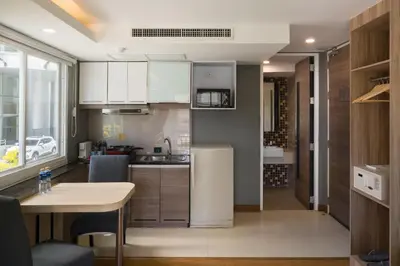a small kitchen with a table and a refrigerator at Aspira Suites Sukhumvit 20 in Bangkok