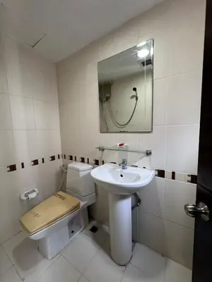 a bathroom with a sink and a toilet and a mirror at Orchid Inn SKV3 in Bangkok