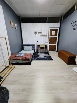 a room with a bed and a table in it at 201-Olan Place Homely room Free Wi-Fi and Near BTS line in Bangkok