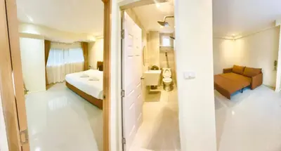 a bedroom with a bed and a couch in a room at ABC HA Hotel Bangkok in Bangkok