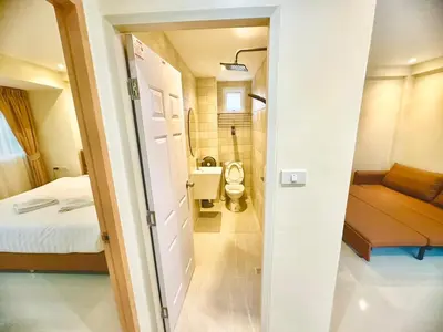 a bathroom with a bed and a toilet in a room at ABC HA Hotel Bangkok in Bangkok