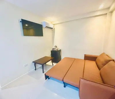 a living room with a couch and a table at ABC HA Hotel Bangkok in Bangkok