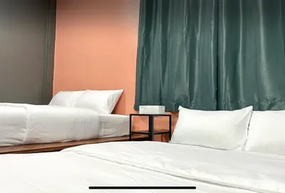 two beds sitting next to each other in a room at Purple House King BR Walk to Grand Palace in Bangkok