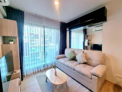 a living room with a couch and a large window at คอนโด 1 ห้องนอน ใกล้บีทีเอสอ่อนนุช สายสีเขียว ที่นอนKing Size วิวสระว่ายน้ำ in Amphoe Phra Khanong