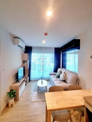 a living room with a couch and a table at คอนโด 1 ห้องนอน ใกล้บีทีเอสอ่อนนุช สายสีเขียว ที่นอนKing Size วิวสระว่ายน้ำ in Amphoe Phra Khanong