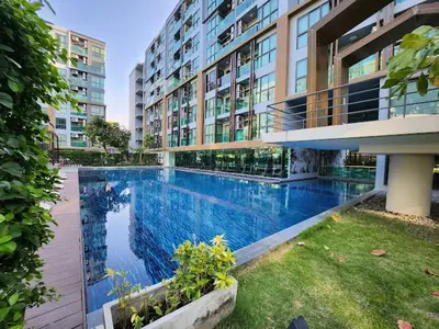 a large apartment building with a large swimming pool at คอนโด 1 ห้องนอน ใกล้บีทีเอสอ่อนนุช สายสีเขียว ที่นอนKing Size วิวสระว่ายน้ำ in Amphoe Phra Khanong