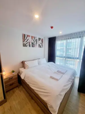 a bedroom with a bed with white sheets and a window at คอนโด 1 ห้องนอน ใกล้บีทีเอสอ่อนนุช สายสีเขียว ที่นอนKing Size วิวสระว่ายน้ำ in Amphoe Phra Khanong
