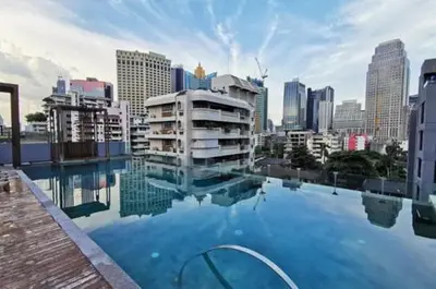 a large swimming pool with a city in the background at Circle S Sukhumvit12 NearBTS,MRT in Bang Kapi