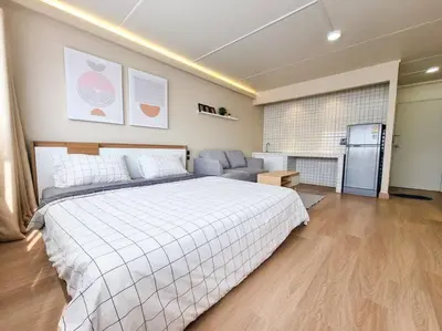 a large bedroom with a bed and a refrigerator at BetterRoom เมืองทองธานี C6 in Pak Kret
