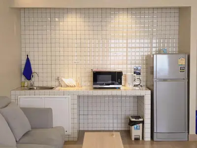 a kitchen with a counter with a tv and a refrigerator at BetterRoom เมืองทองธานี C6 in Pak Kret