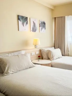 a hotel room with two beds and a couch at ห้องพักเมืองทองธานี Happiness Sleep P1 in Ban Song Hong