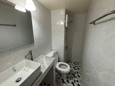 a white bathroom with a toilet and a sink at Impact Donmuang Popular Condo C5 in Bangkok