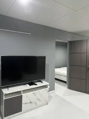 a living room with a flat screen tv and a bedroom at Impact Donmuang Popular Condo C5 in Bangkok