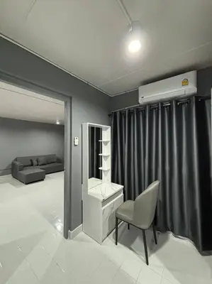 a living room with a chair and a desk at Impact Donmuang Popular Condo C5 in Bangkok