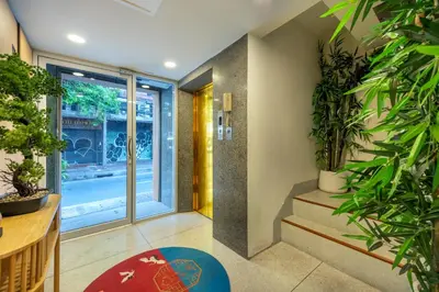 a hallway with plants and stairs with a window at SHIN Hotel Chinatown in Khlong San